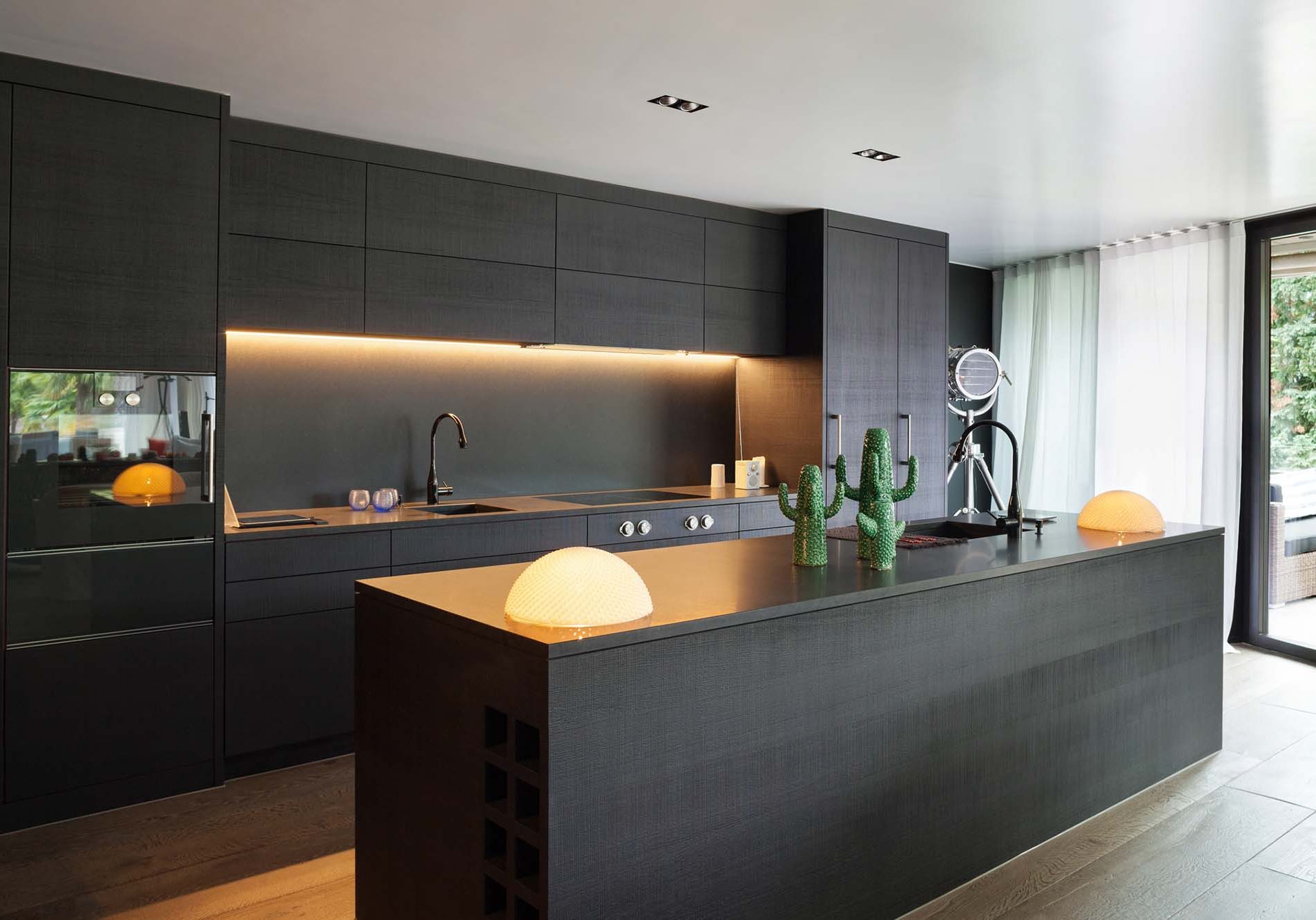 Modern kitchen with black furniture and wooden floor